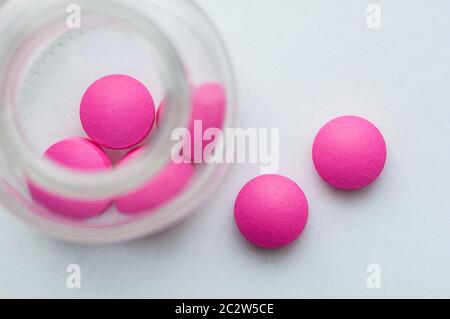 Rosa Pillen sind aus Glas auf einem weißen Hintergrund gegossen. Der Blick von oben Stockfoto
