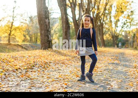 Weiter lernen. Kleines Kind genießt das Lernen im Herbstpark. Kinderstudium mit Buch. Kleines Mädchen lesen Buch am Herbsttag. Literaturkonzept Herbst. Klein Stockfoto