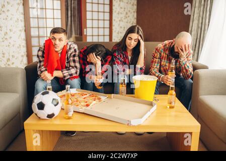 Fußball-Fans leider wathing TV-Sendung zu Hause. Gruppe von Menschen, die für ihre Lieblingsmannschaft zu verlieren. Stockfoto