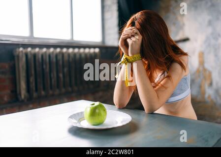 Womans Hände sind mit Maßband gegen die Platte mit Apple gebunden. Fett oder Kalorien verbrennen. Gewichtsverlust Stockfoto