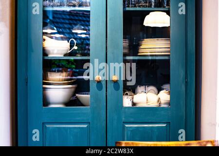 Verschiedene weiße Geschirr im Schrank in der Küche Vintage-Design mit blauen Farben Retro Stockfoto