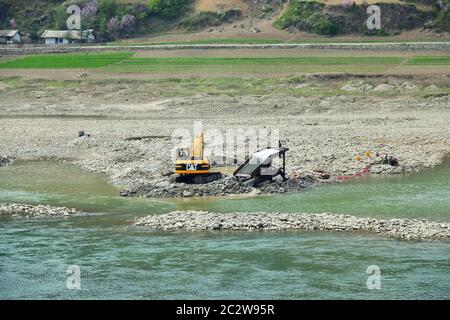 Provinz Südpyongan, Nordkorea - 30. April 2019: Goldbergbau am Fluss Taedong. Die Arbeiter auf dem Bagger wuschen den Goldstaub Stockfoto