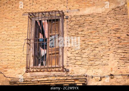 Fenster schützen vor rostigen Metallbarren an der Ziegelwand eines zerstörten Gebäudes Stockfoto