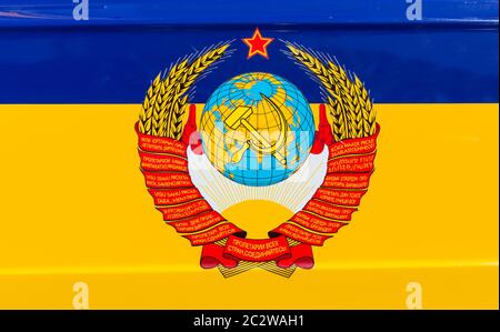 Staatliche Wappen der UdSSR über ukrainische Flagge Stockfoto