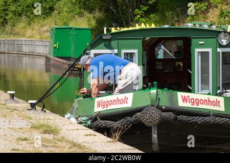 Wey und Arun Canal Trust arbeiten ehrenamtlich, Mann malt ein Schmalboot, West Sussex, Großbritannien Stockfoto