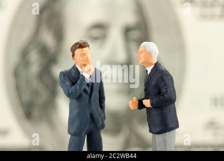 Miniatur-Figuren von zwei Geschäftsleute diskutieren. Detailansicht Stockfoto