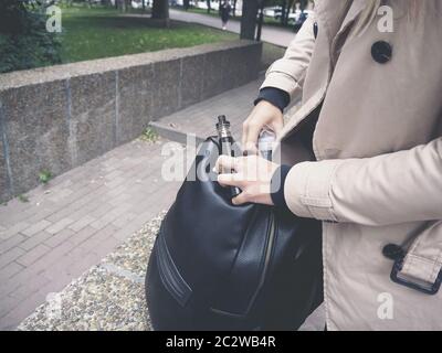 Blonde Mädchen in beige Trenchcoat Verdampfung Obst e-Flüssigkeit mit sehr beliebten Vaporizer Gerät Stockfoto