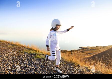 Astronaut futuristische Mädchen mit weißen durchgehenden Uniform und Helm tragen silberne Schuhe im Freien Stockfoto