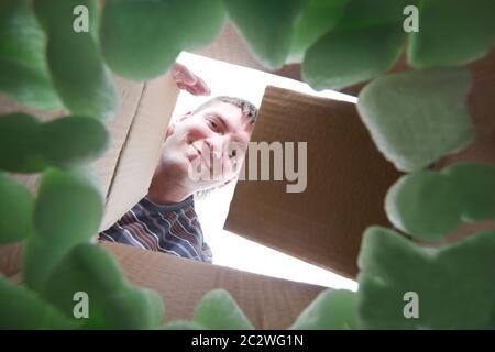 Lächelnd jungen Mann einmündende Karton Stockfoto