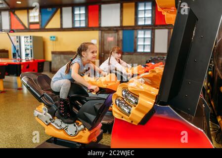 Zwei kleine Mädchen spielt, Spiel, Kinder Entertainment Center. Aufgeregt childs Spaß auf dem Spielplatz im Freien. Kinder spielen auf Motorrädern, Amus Stockfoto