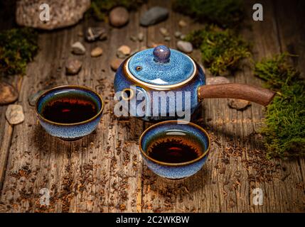Chinesische Teezeremonie. Teekanne und Tasse aus Keramik auf Holzgrund Stockfoto