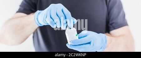 Handdesinfektionsmittel Hygiene Alkohol Gel Flaschen in den Händen des Mannes trägt Latex medizinische Handschuhe und Schutzmaske während Coronavirus COVID-19 Pandemien. Hea Stockfoto