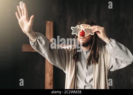 Der Mensch nach dem Bild Jesu Christi in Partei Gläser aus seiner Hand, Kreuzigung Kreuz auf schwarzem Hintergrund Stockfoto
