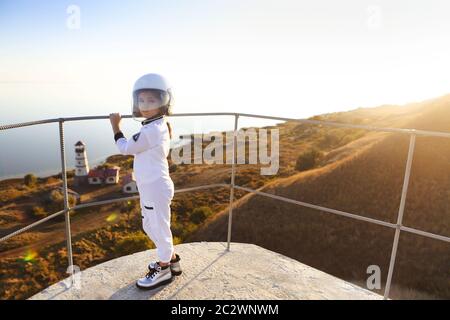 Astronaut futuristische Mädchen mit weißen durchgehenden Uniform und Helm tragen silberne Schuhe im Freien Stockfoto