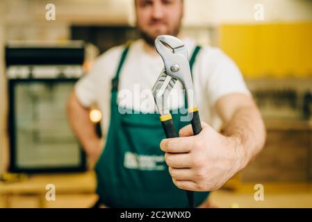 Handwerker in Uniform hält Schraubenschlüssel, Heimwerker. Professionelle Arbeiter macht Reparaturen rund um das Haus, home Reparatur Service Stockfoto