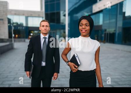 Business-frau und Geschäftsmann mit Laptops in den Händen im freien, modernen Bürogebäude auf Hintergrund, Partnerschaft Verhandlungen während der Mittagspause. Stockfoto