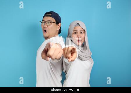 Portait von glücklich asiatischen muslimischen Paar lächelnd und zeigt auf Kamera, Mann und Frau umarmt voller Liebe, Familienkonzept Stockfoto