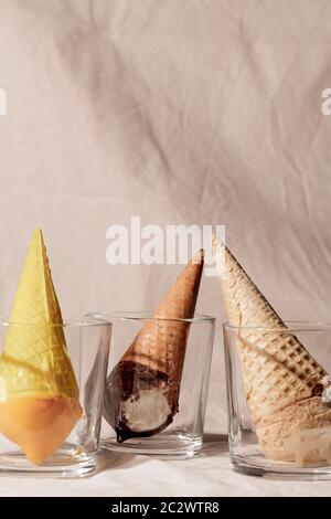 Verschiedene Eis Waffel Kegel in Glas auf beige Pastell Hintergrund.Mode Lebensmittel Zusammensetzung Stockfoto
