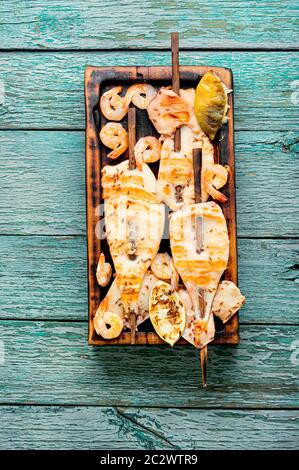 Gegrillte Quietschspieße auf einer Küchenplatte. Gegrillter Kalamari Stockfoto