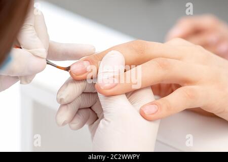 Nahaufnahme der Hand der Manikurist Anwendung klaren Nagellack im Schönheitssalon. Stockfoto