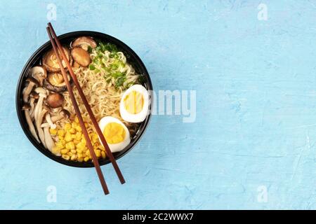 Ramen. Soba Nudeln mit Eiern, Shiitake-Pilze und Gemüse, über Kopf Schuss auf blauem Hintergrund mit Essstäbchen und Copysp Stockfoto