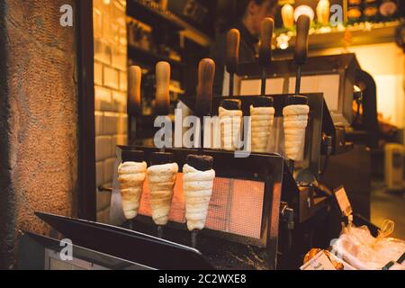 Traditionelle Street Food des Landes Tschechische Republik. Vorbereitung von Trdelnik - traditionelle tschechische Bäckerei. Tschechische süße Gebäck genannt T Stockfoto