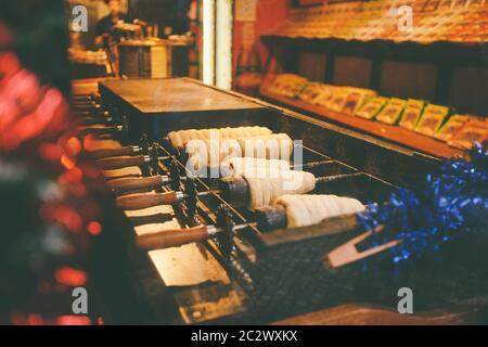 Traditionelle Street Food des Landes Tschechische Republik. Vorbereitung von Trdelnik - traditionelle tschechische Bäckerei. Tschechische süße Gebäck genannt T Stockfoto