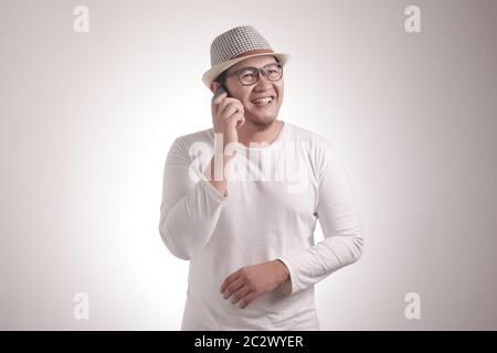 Attraktiver junger asiatischer Mann, der am Telefon spricht, lächelnd lächelnd lächelnde Geste Stockfoto