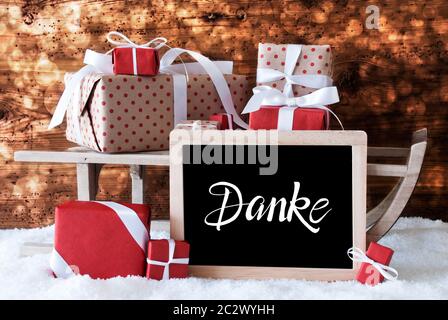 Tafel mit Deutschen Kalligraphie Frohe Weihnachten und ein Glueckliches 2020 bedeutet, frohe Weihnachten und einen guten Rutsch ins Jahr 2020. Schlitten mit Weihnachtsgeschenk und Pr Stockfoto