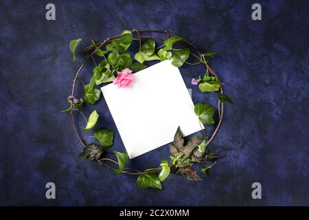Design-Vorlage für Einladung oder Grußkarte mit einem flachen Kranz aus Blättern und Blumen, Topshot mit Kopierfläche. Efeu und Rose Stockfoto