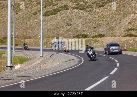 Alta, Russland - 06.02.2020: Berg Asphaltstraße in Altai mit drei Motorrädern und Motorradfahrern in Helmen, die sich einer nach dem anderen in eine Richtung bewegen und tw Stockfoto