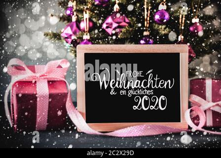Tafel mit Deutschen Kalligraphie Frohe Weihnachten und ein Glueckliches 2020 bedeuten Frohe Weihnachten und guten Rutsch ins Jahr 2020. Weihnachtsbaum mit Lila Kugel oder Stockfoto