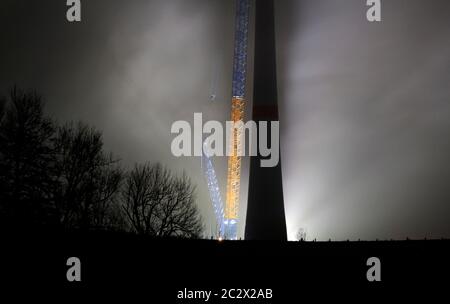Montage der Windenergieanlage, beleuchtet in der Nacht Stockfoto