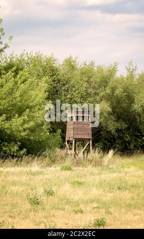 Ein hölzerner Hochsitz für die Jagd am Waldrand auf einer Lichtung Stockfoto