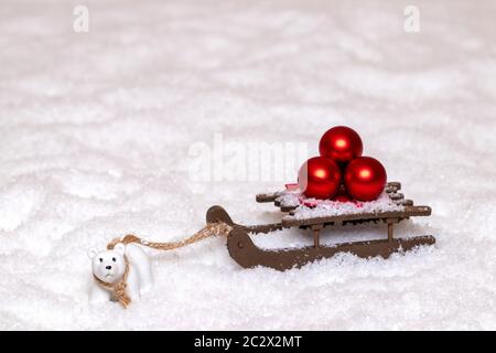 Weihnachten Grußkarte Vorlage. Eine kleine Eisbär zieht einen Schlitten mit drei roten Weihnachtskugeln durch den Schnee. Kopieren Sie Raum für Ihre Konstruktion. Pan Stockfoto