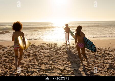 Junge Mischrenner halten Surfbretter am Strand Stockfoto