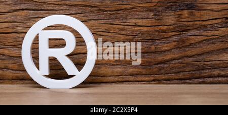 Eingetragenes Markenschild Leaning On Wooden Wall Stockfoto