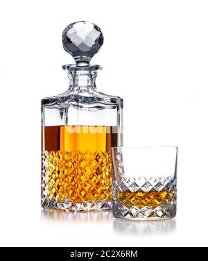 Ein halb voller Kristall Whisky Dekanter und Kristallglas, mit goldenem Whisky, auf Weiß geschossen, mit einer kleinen Reflexion Stockfoto