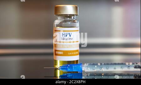 HPV oder das humane Papillomavirus. Flasche Impfstoff HPV auf schwarzem Tisch auf Edelstahl Hintergrund. Stockfoto