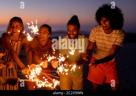 Multiethnische Gruppe von männlichen und weiblichen Tänzen mit Feuerwerkskörper Stockfoto