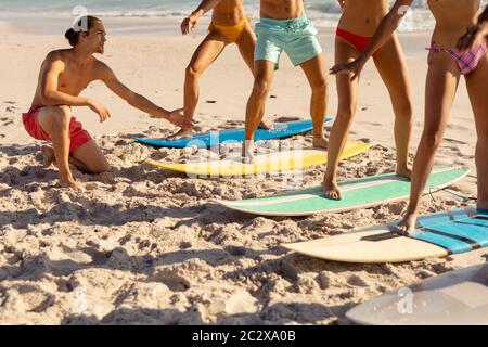 Multiethnische Gruppe von Männern und Frauen, Surfen am Strand Stockfoto