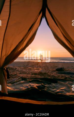 Blick durch die Tür von orange und grau Zelt Camping Sommer Strand Hintergrund. Stockfoto