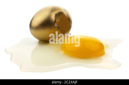Gebrochenes goldenes Ei isoliert auf weißem Hintergrund. Stockfoto