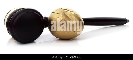 Gebrochenes goldenes Ei mit Hammer auf weißem Hintergrund. Stockfoto
