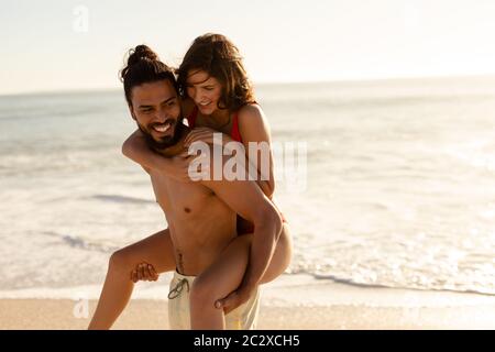 Multiethnisches Paar, das Spaß am Strand hat Stockfoto