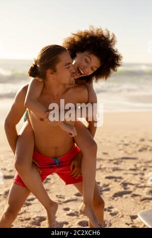Multiethnisches Paar, das Spaß am Strand hat Stockfoto