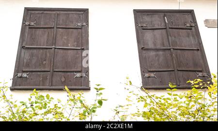 Fenster mit Fensterläden aus Holz in eine weiße Wand. Hintergrundbild. Für Text platzieren. Stockfoto