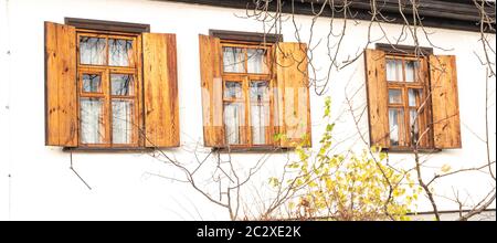 Fenster mit Fensterläden aus Holz in eine weiße Wand. Hintergrundbild. Für Text platzieren. Stockfoto