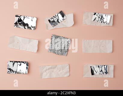Verschiedene zerknitterte Folien verwendeten Süßigkeiten-Wrapper auf beigefarbenem Hintergrund, Draufsicht Stockfoto