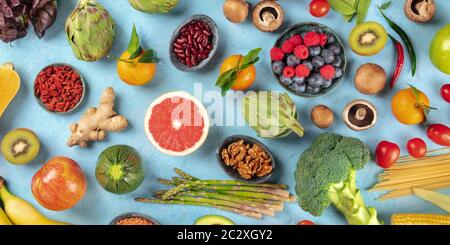 Veganes Food Panorama. Gesunde Ernährung Konzept. Obst, Gemüse, Nüsse, Hülsenfrüchte, Pilze, von oben auf blauem Hintergrund geschossen, Stockfoto